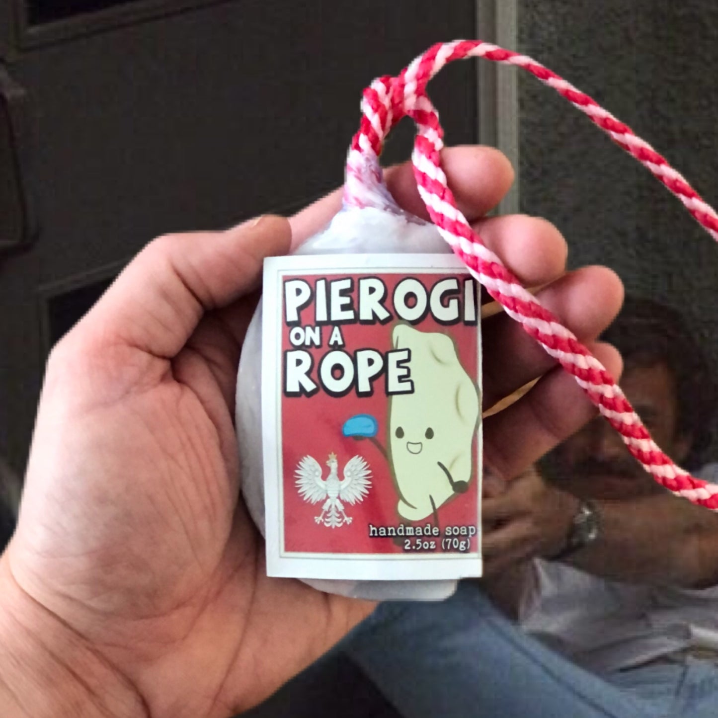 a hand holding a soap on a rope from regent park naturals pierogi