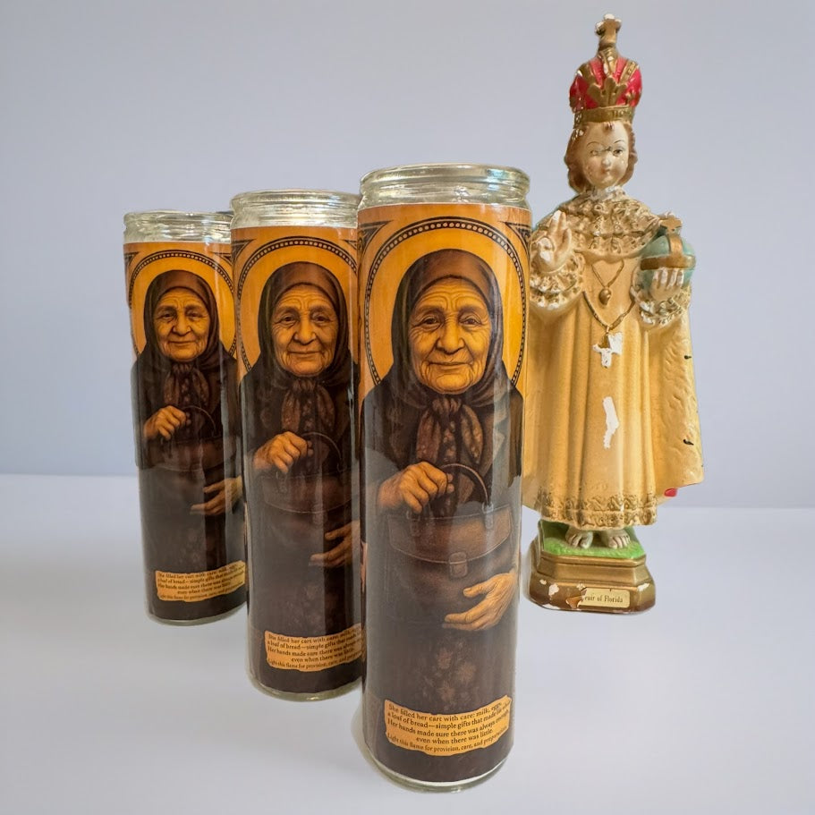 Set of four prayer candles with images of elderly women and a statue of a religious figure on a white background.