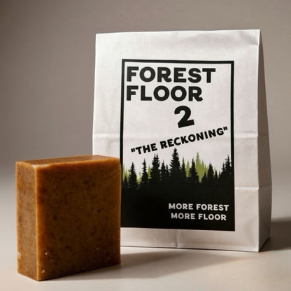 Bar of soap next to a packaging bag with 'Forest Floor 2' design on a neutral background