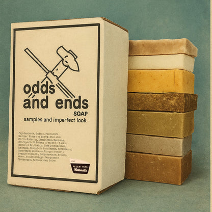 Box of 'odds ánd ends SOAP' with a stack of soap bars on a green background