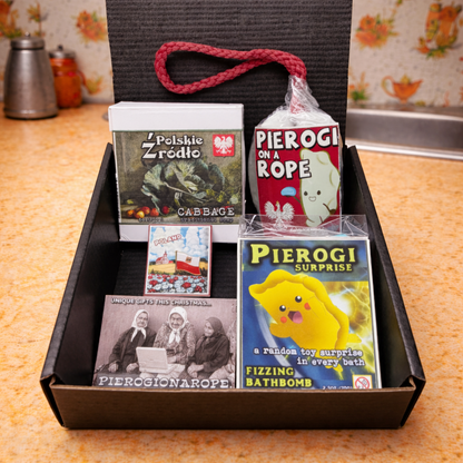 Box with pierogi-themed products including books and a bath bomb on a kitchen counter.
