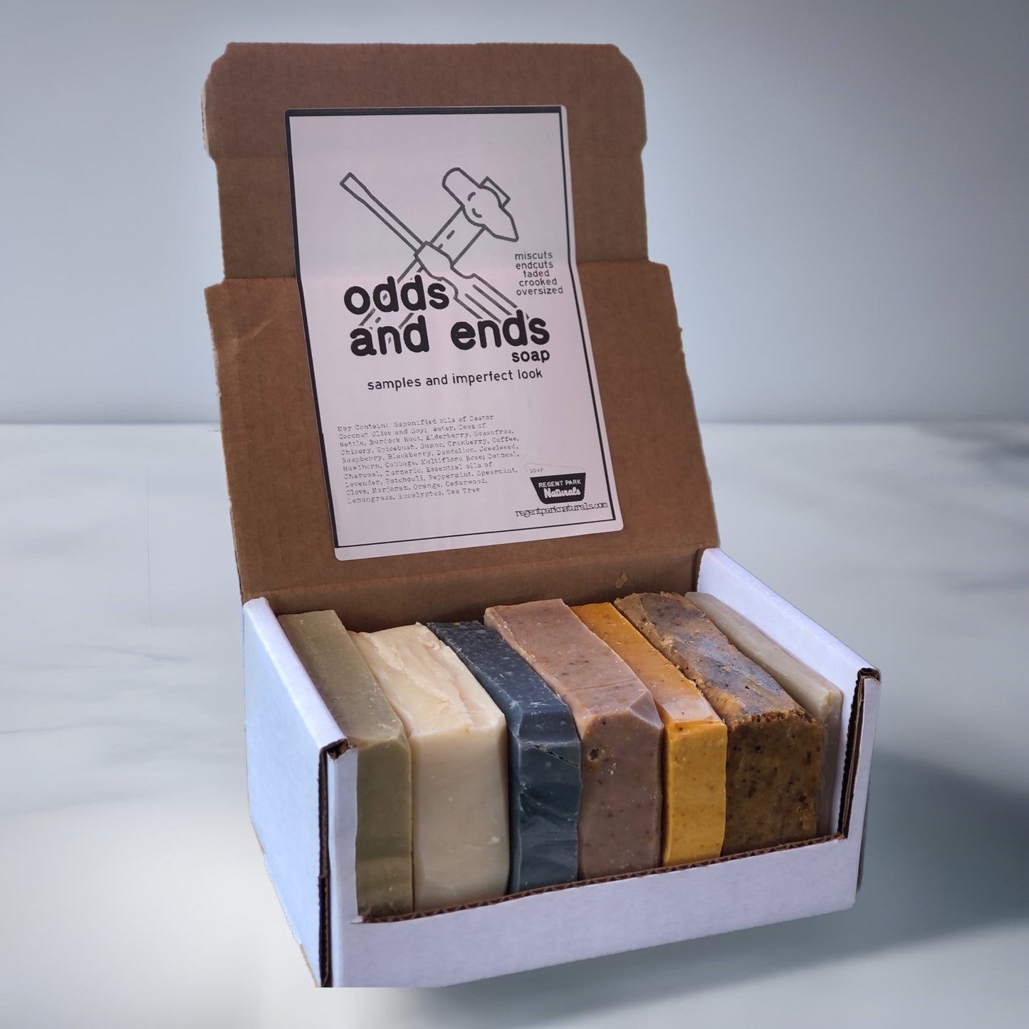 Box of assorted soap bars with 'odds and ends soap' branding on a light gray background