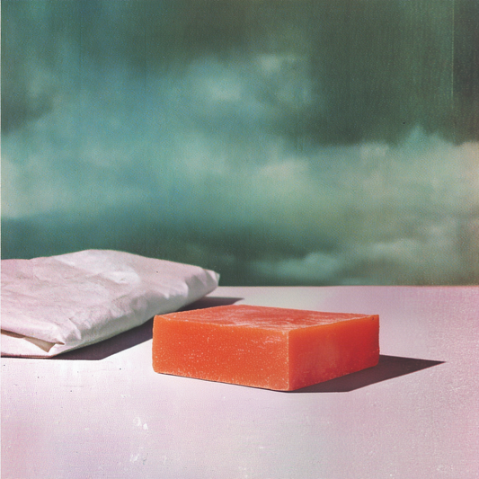 Red soap bar on a white surface with a blurred green background