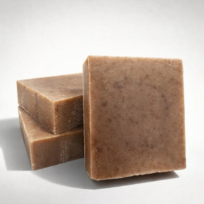Three bars of brown soap stacked on a white background